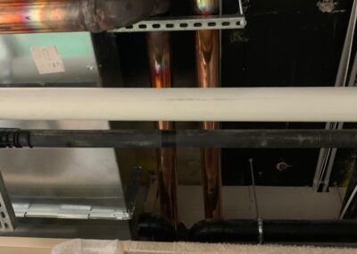 Copper and black pipes installed on a ceiling with insulation and metal ductwork nearby. - Fosker Plumbing Western Sydney