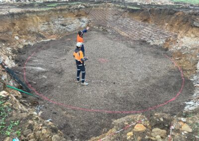Two construction workers standing inside a large circular excavation marked with pink lines. - Fosker Plumbing Western Sydney