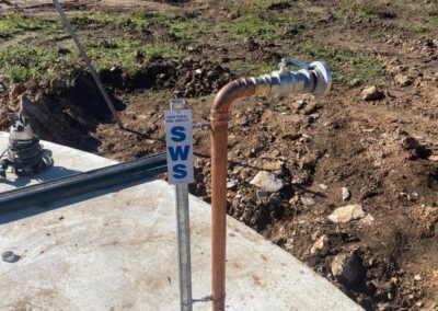 Copper water pipe with valve and NSW Rural Fire Service SWS sign installed on concrete slab. - Fosker Plumbing Western Sydney